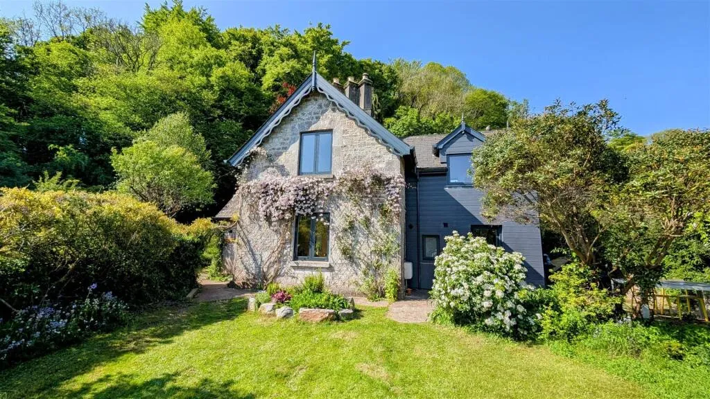 A house in the middle of a lush green field.