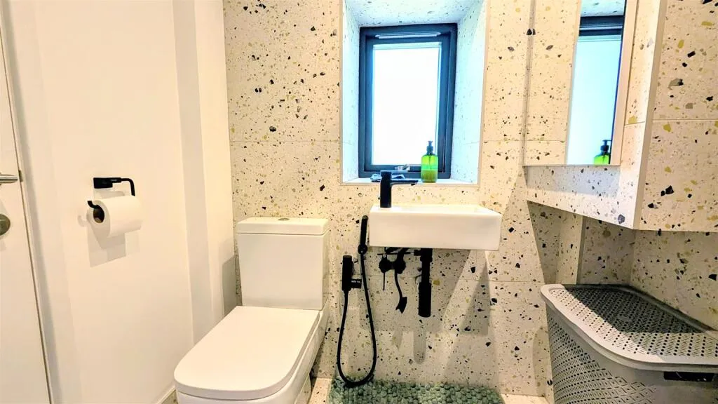 A bathroom with a toilet, sink, and shower.