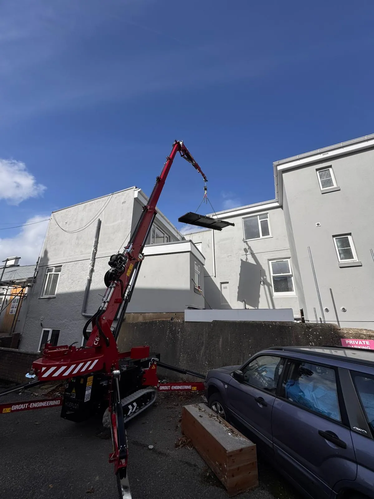 A red crane is parked in a parking lot.