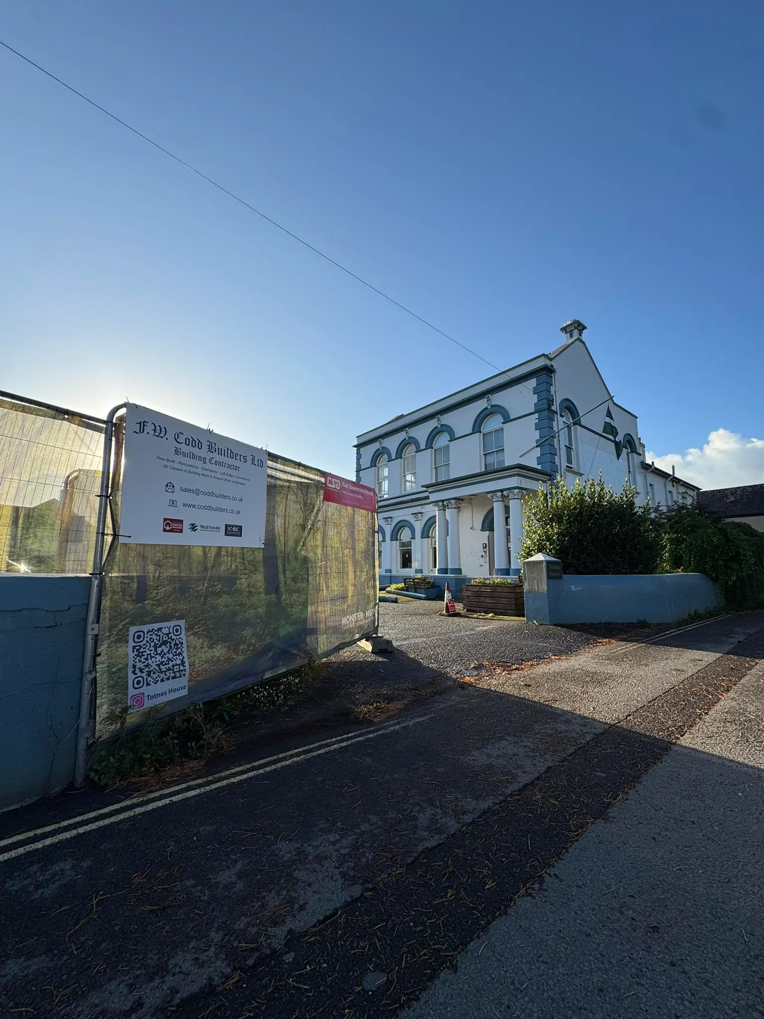 A large white house sitting next to a road.