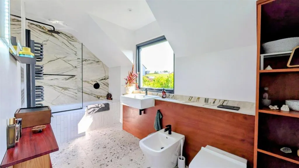 A bathroom with a sink, toilet and a window.